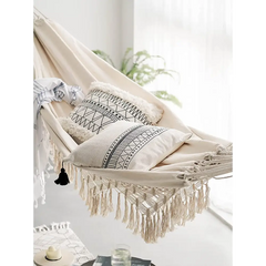 Bohemian hammock with pillows and macrame fringe for outdoor relaxation comfort
