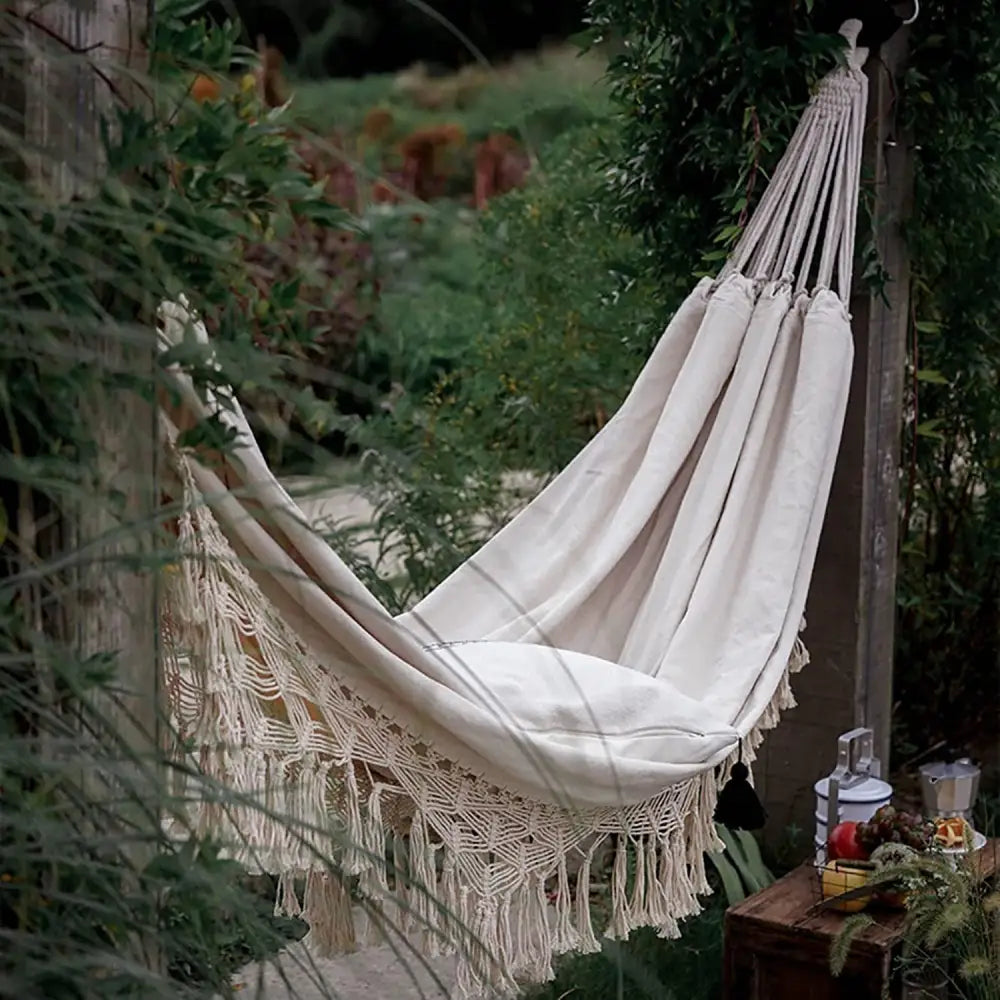Cream-colored Boho Macrame Hammock with fringe for comfortable outdoor relaxation